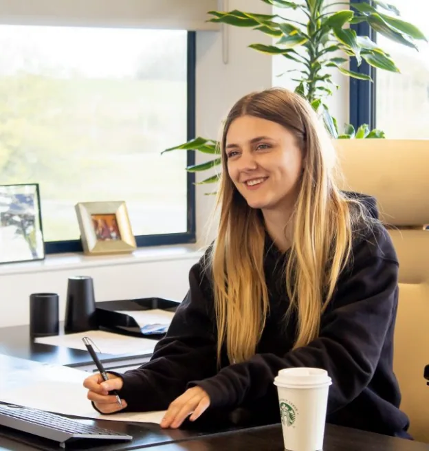 A Propeller Pay team member smiling at her desk